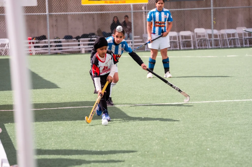 Wolverines youth players in intense battle for ball control on turf